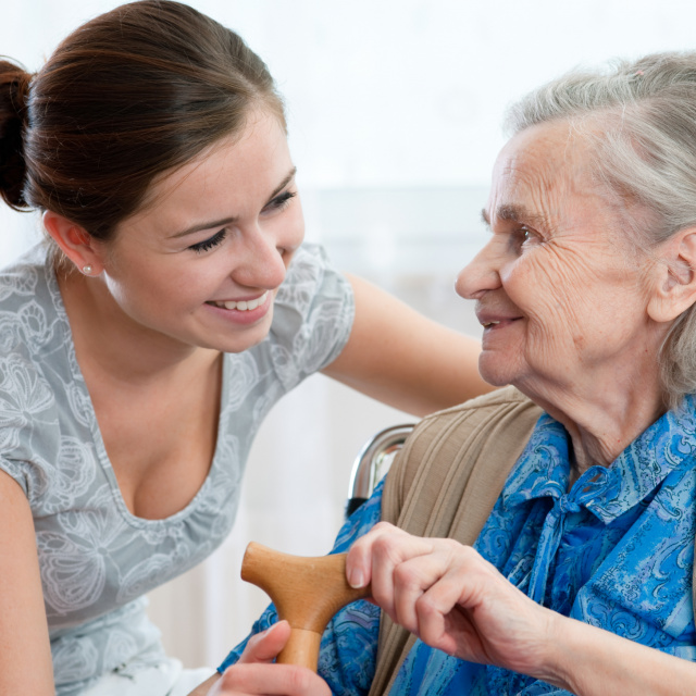 Nurse and elderly woman with walking stick