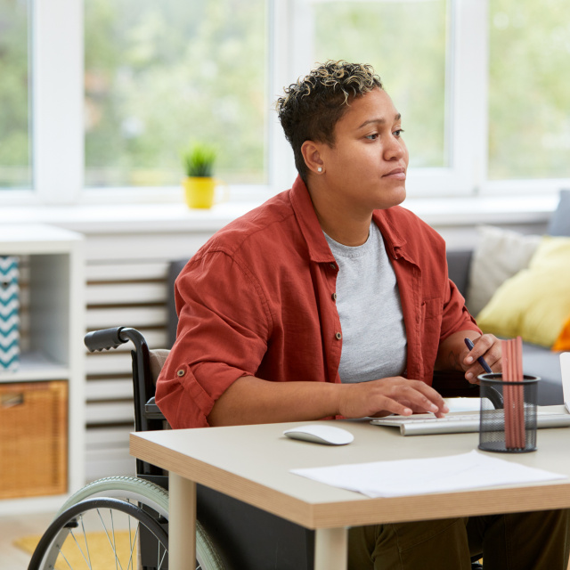 Woman in wheelchair at work on computer