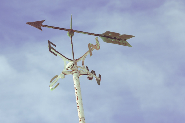 Weather vane against blue sky